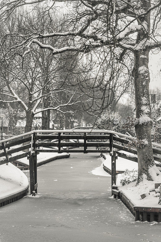 在一个寒冷但美丽而平静的冬天，Giethoorn村的运河和积雪