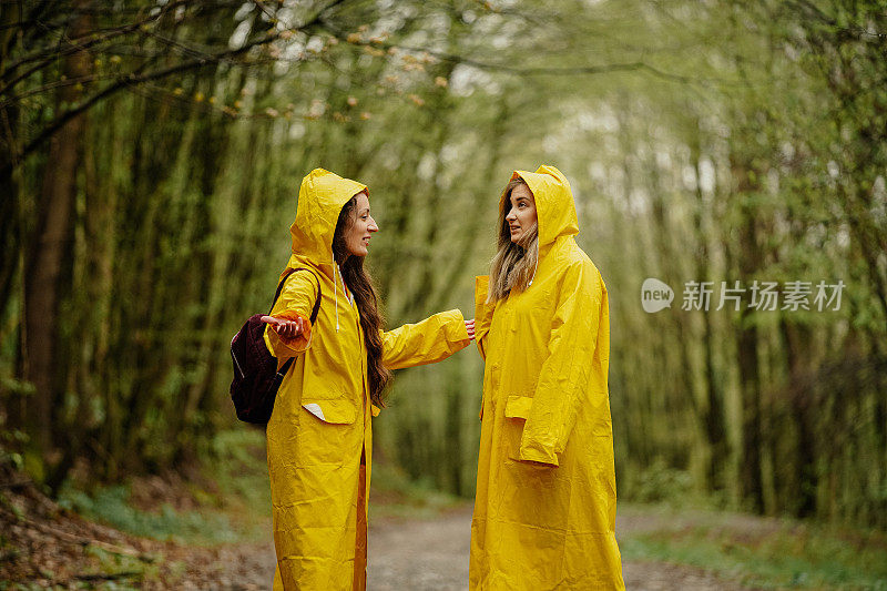 两个穿着黄色雨衣的年轻女子在雨中