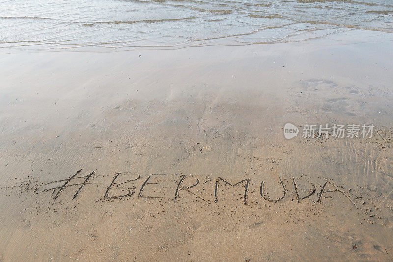 图片的标签标签写在阳光明媚的海滩上，百慕大字写在海边的沙子，帕洛伦海滩，印度果阿，概念社交媒体照片的手写在金色的沙子与现代标签前缀