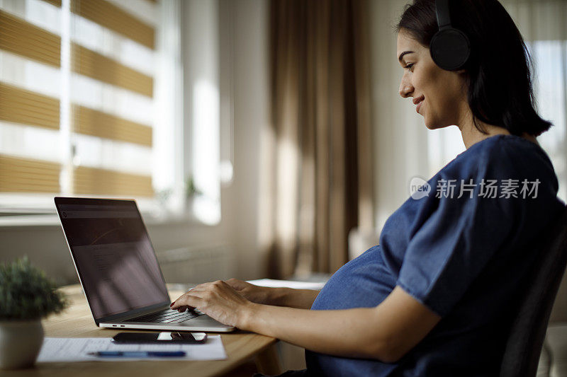 孕妇戴耳机使用笔记本电脑
