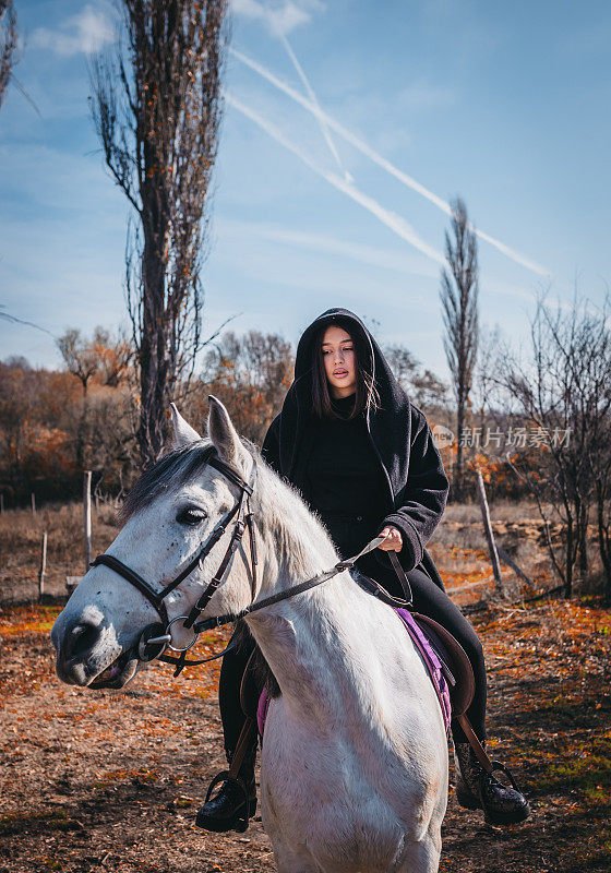 在一个阳光明媚的日子里，一个女人牵着一匹马在牧场上