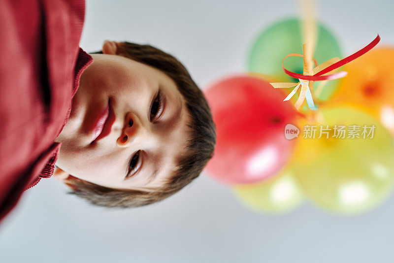 可爱的孩子在家里玩五颜六色的氦气球。