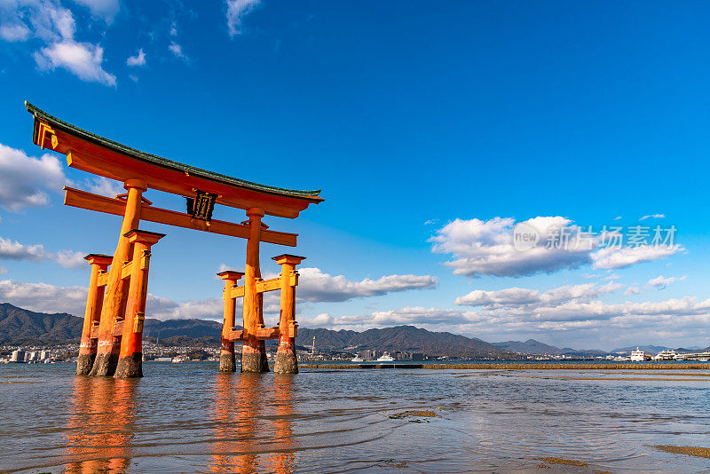 漂浮的红色巨型大鸟居门矗立在宫岛湾海滩上