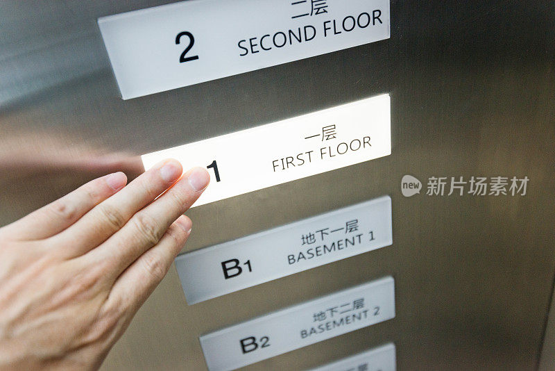 女人在电梯里用手按按钮