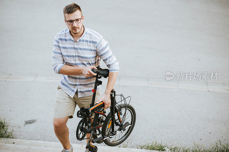 一个年轻人骑着他的折叠自行车爬楼梯