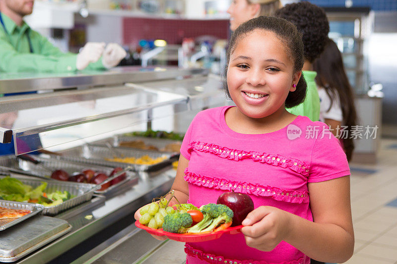 可爱的小学生在学校食堂选择健康食品