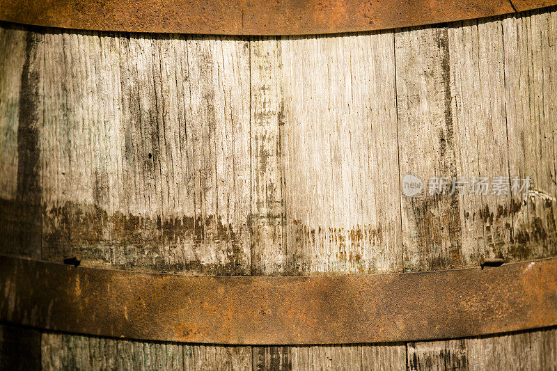 背景:一个古老的木制威士忌酒桶的特写。
