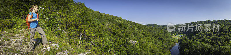 女孩徒步俯瞰绿色的森林，蓝色的河流，夏天的山谷全景