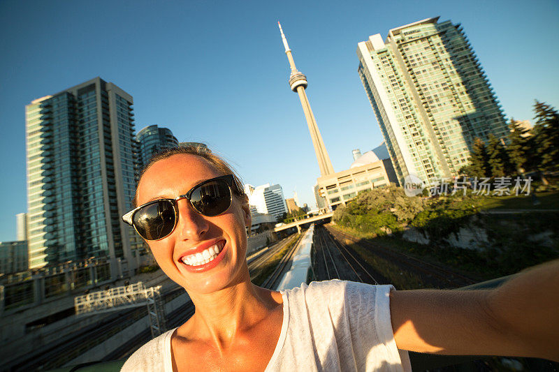 年轻女子在多伦多旅行，与城市风景自拍
