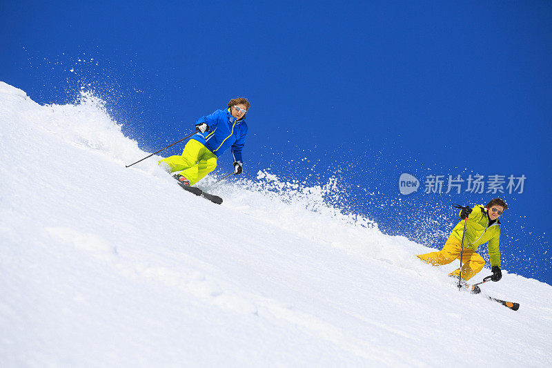 两个男人在阳光明媚的滑雪胜地滑雪