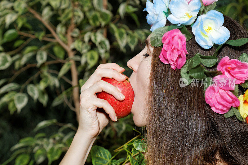 小女孩在咬苹果。夏娃的诱惑。