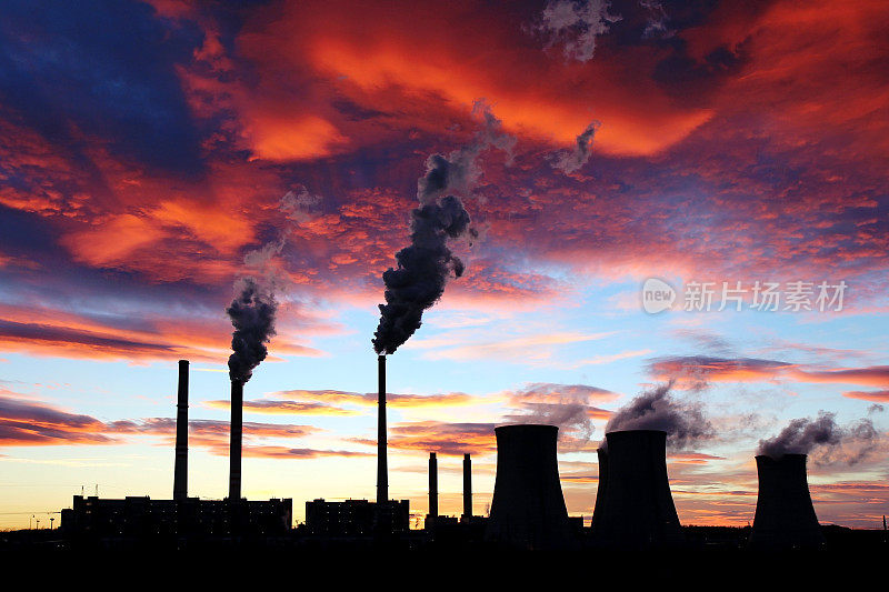 戏剧性的日落在天空和火力发电厂的工厂