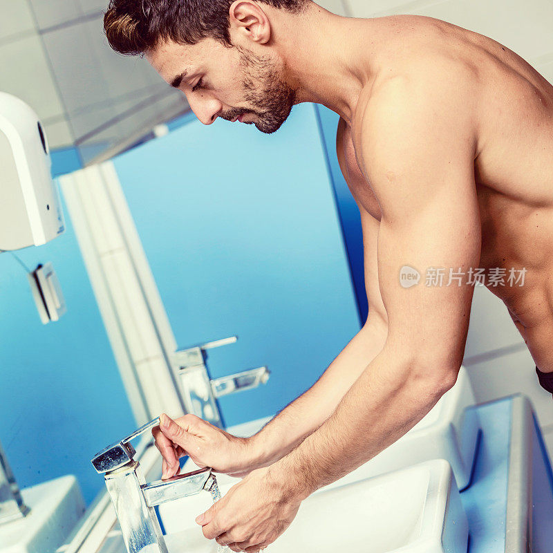 在浴室里洗脸的男人