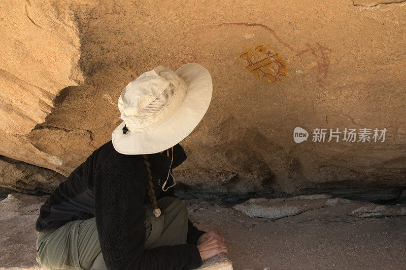 年轻女子研究美国本土岩石艺术Hueco坦克德克萨斯州