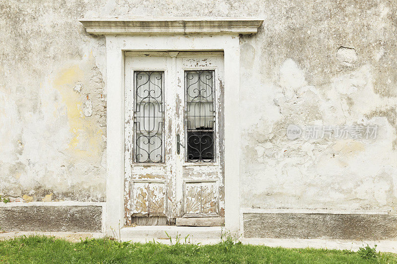 克罗地亚墙中风化的白色木质历史门