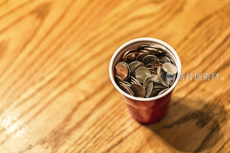美国硬币堆在塑料钱杯