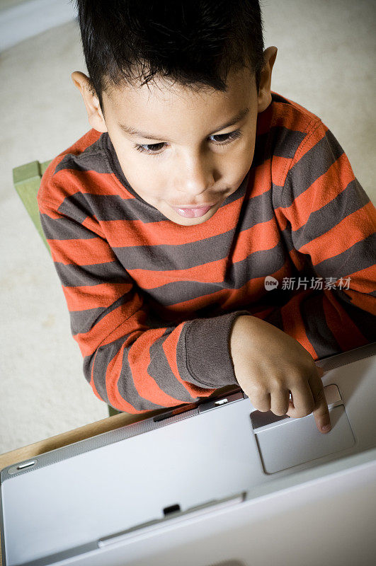 小男孩在用笔记本电脑