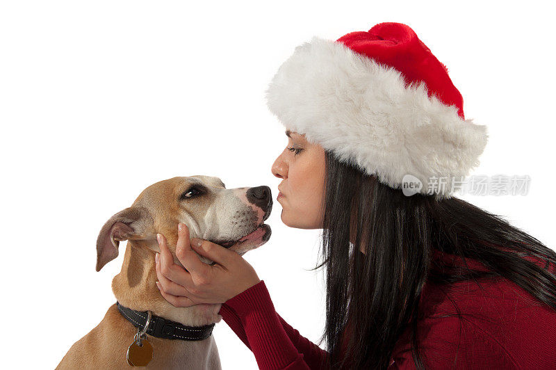 戴着圣诞帽的年轻女子与狗在白色隔离