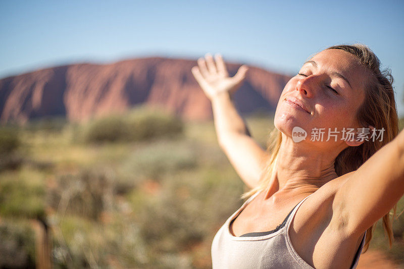 年轻女子张开双臂，渴望自由和积极的情绪