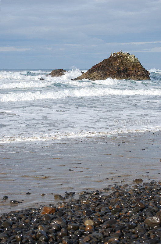 海浪撞击着海洋中的一块大石头。