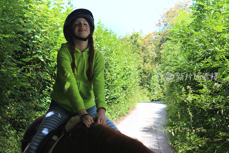 小女孩享受着骑马课，戴着骑马帽