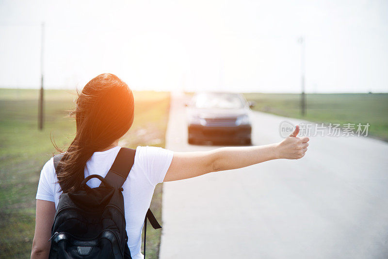 女人竖起大拇指让她搭车