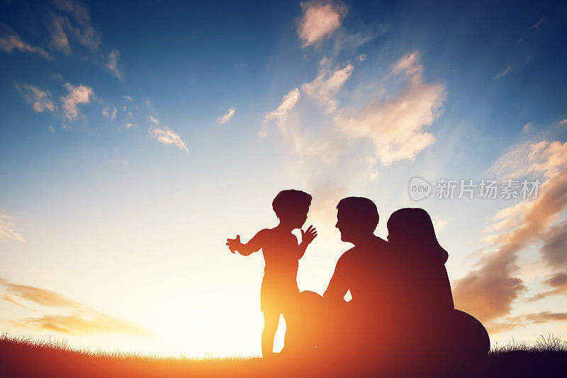 幸福的家庭在一起，父母和他们的孩子在日落。