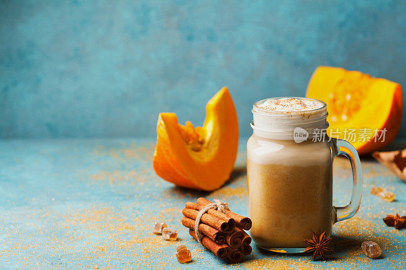 舒适的早餐或零食南瓜香料拿铁或咖啡杯在绿松石古董桌上。秋冬热饮。
