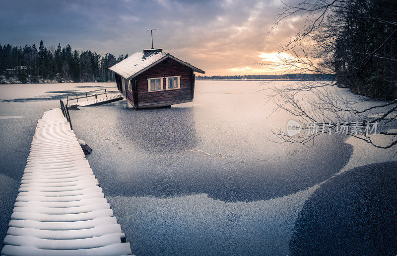 芬兰，冬日傍晚日落时分的废弃小屋