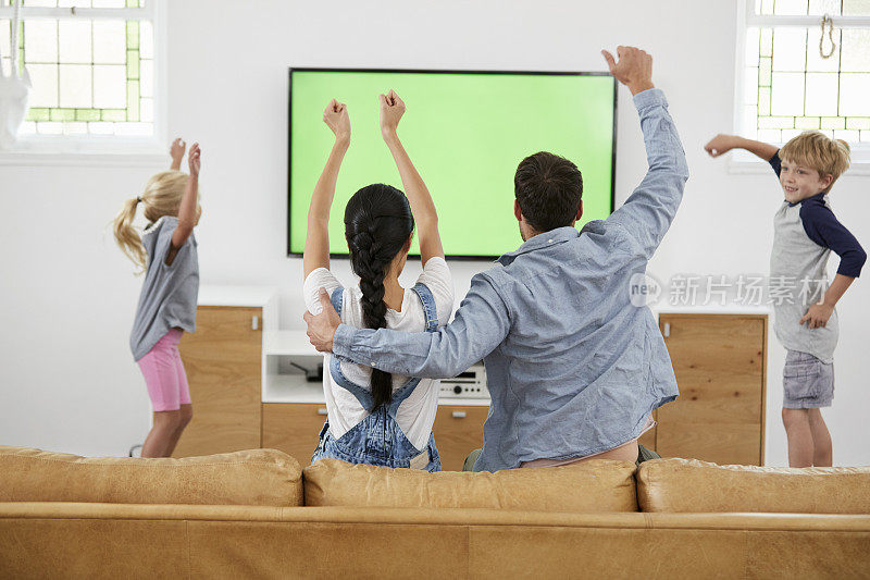 家人看电视上的体育节目和欢呼
