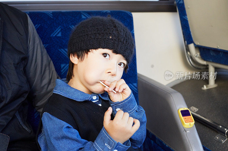 拿着棒棒糖的男孩在公车上很开心