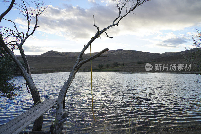 游泳洞，池塘与自制的跳水板和绳索秋千在日落内华达沙漠。