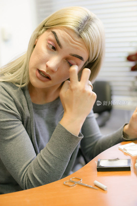 年轻女孩把她的假睫毛