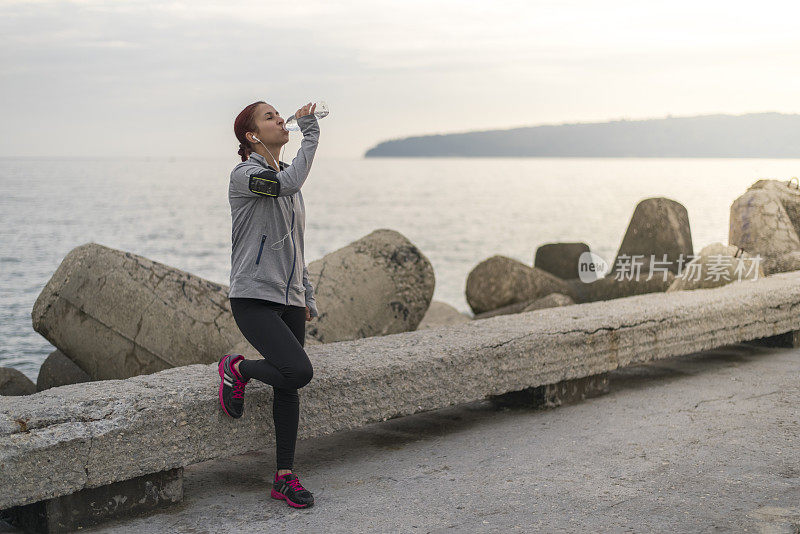 健身女性在腹股沟锻炼后喝水