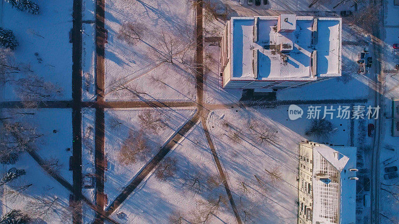 俯视图，正上方鸟瞰被雪覆盖的冬季城市住宅区。复杂的攀爬和旋转摄像机运动