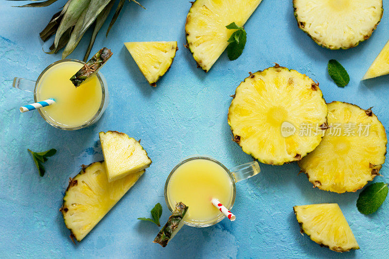 自制清爽水果饮料，配菠萝、新鲜维生素。寒冷的夏季饮料。俯视图平铺背景。