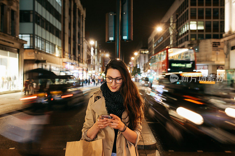一个年轻女子的肖像，在繁忙的街道上的伦敦市中心在晚上