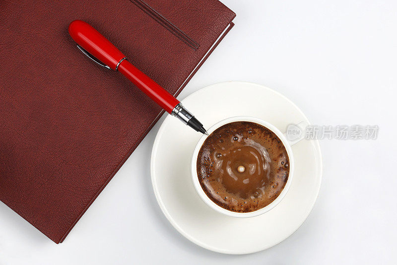 白色背景上的记事本、钢笔和咖啡杯
