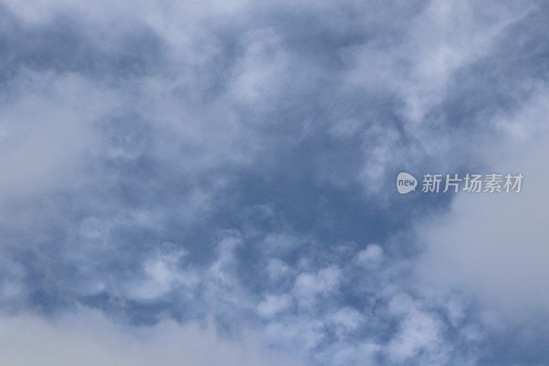 蓝色的天空中，蓬松、缕缕的白色积云