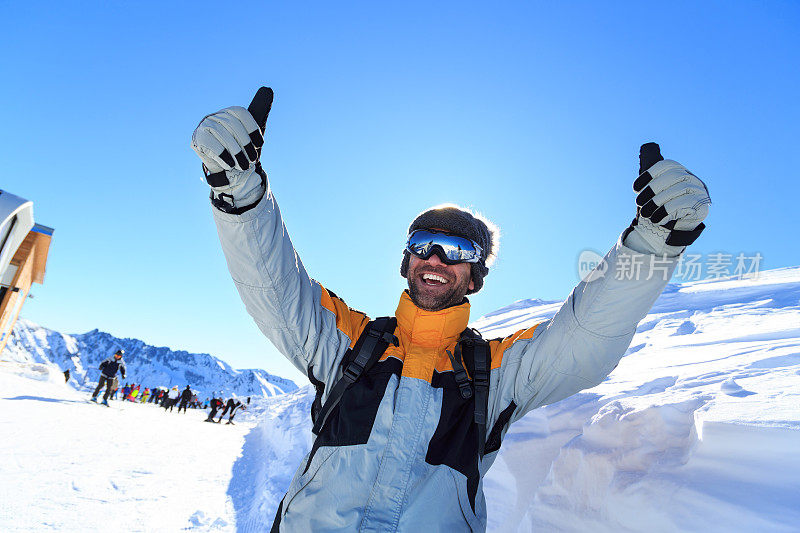 男性背包客在雪山上竖起大拇指