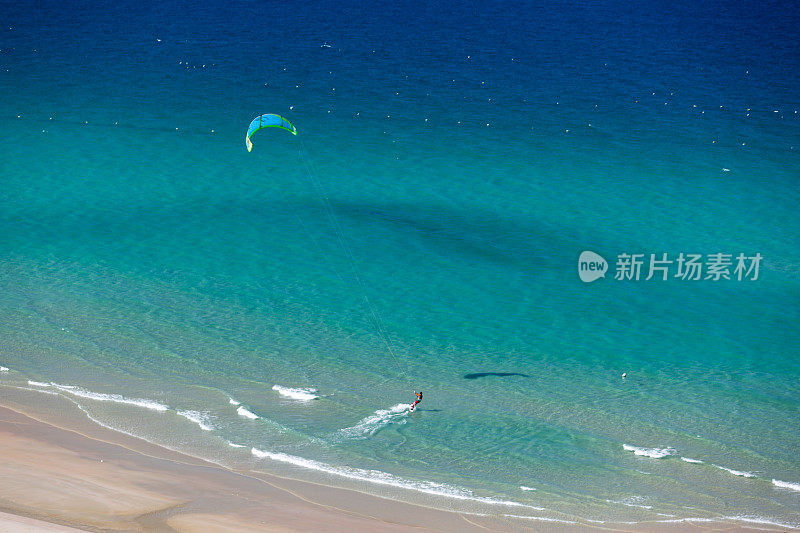 风筝冲浪在热带碧水海滩上从空中鸟瞰拍摄的照片