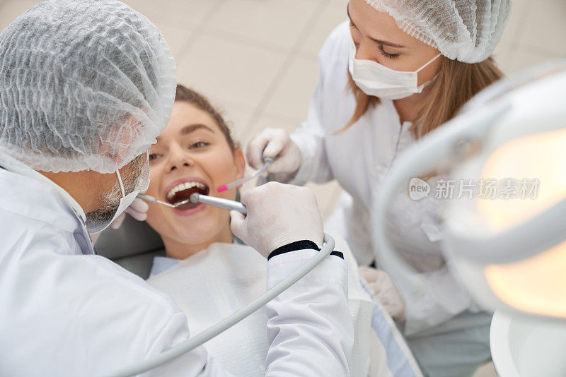牙医使用修复工具的女人与张开的嘴。