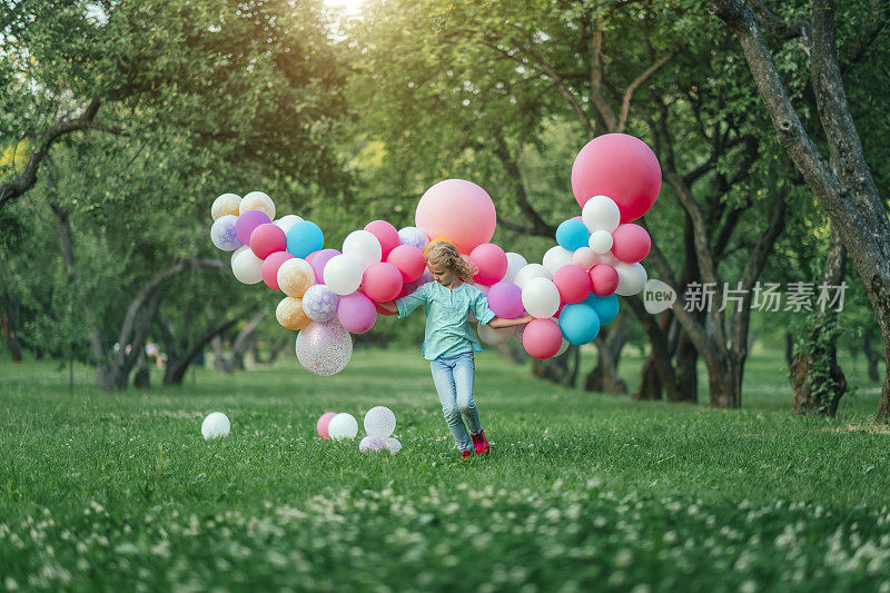 小女孩在公园里奔跑，气球就像她的翅膀