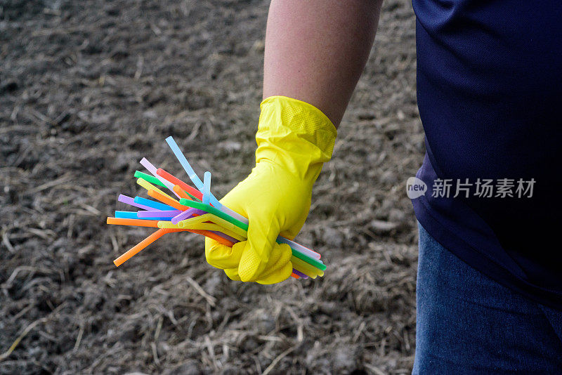 手持塑料吸管手套的手的特写——生态产业理念