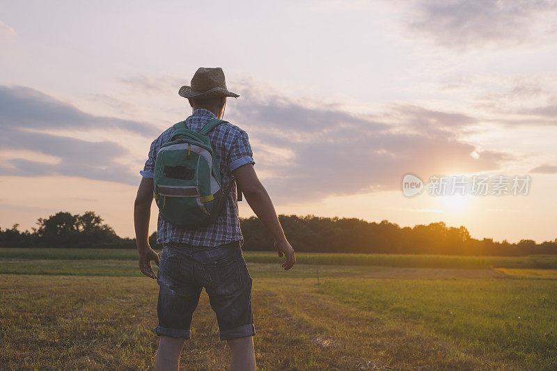 成年男子冒险家徒步在美丽的夏日日落大自然