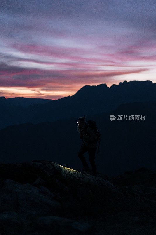 日出时，女徒步旅行者穿过山脊