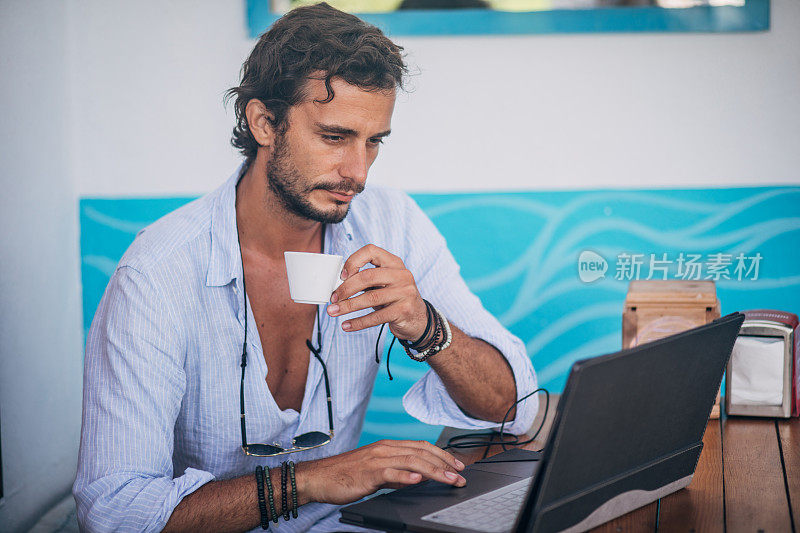 在咖啡馆用笔记本电脑工作的年轻人