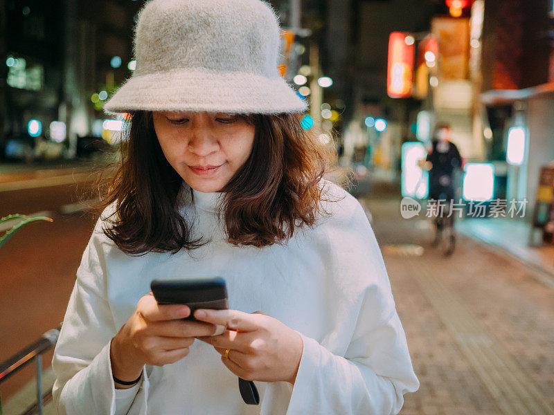 在日本，一个女人在户外发短信。