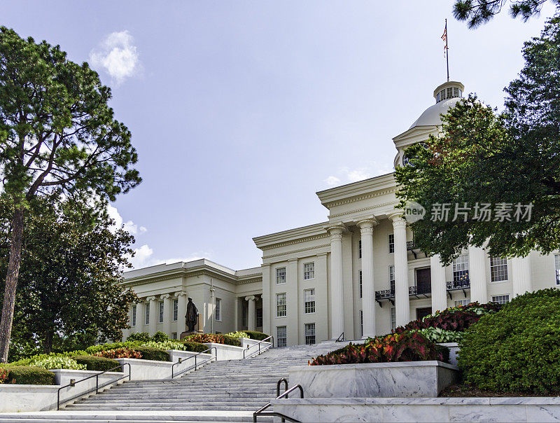 蒙哥马利阿拉巴马州国会大厦有柱子，台阶，圆顶，旗帜和时钟显示