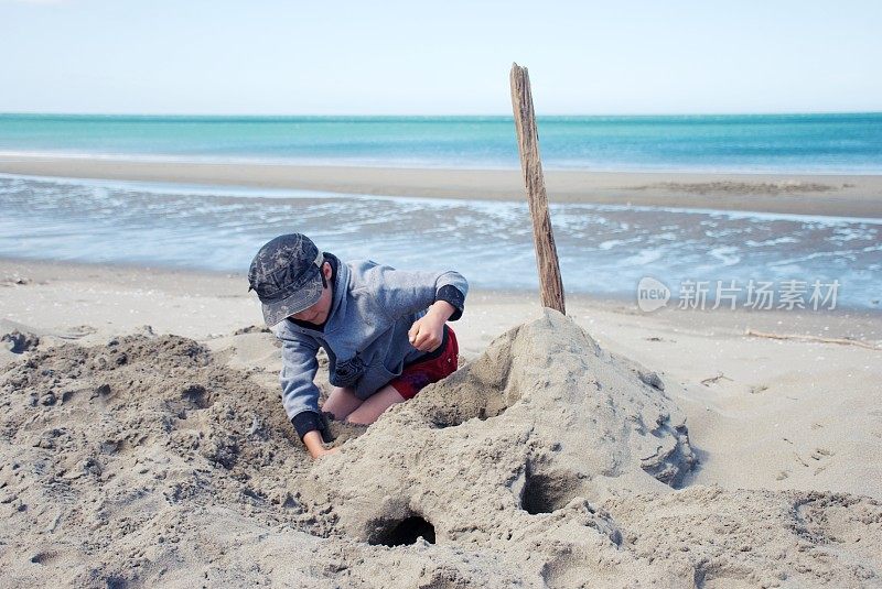 在海滩上建造沙堡的孩子